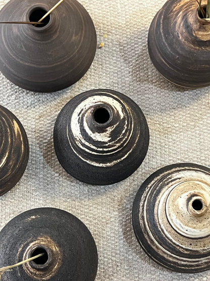 Black and white textured vases on a linen fabric surface
